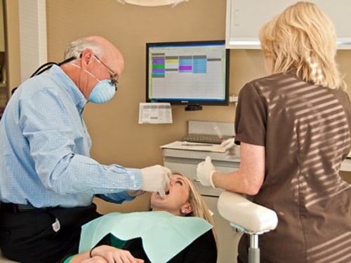 Dr. Picket with dental assistant treating patient